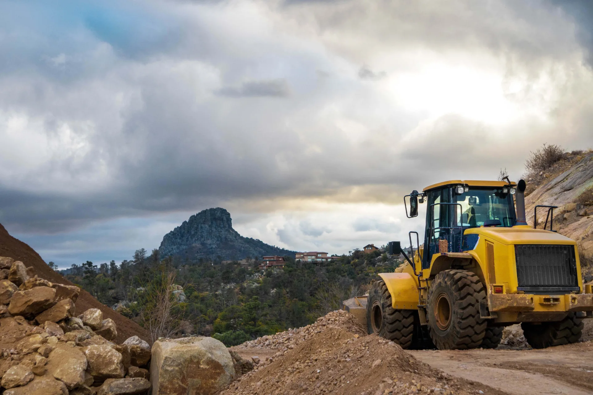 Wheel loader grading a rocky hillside cut for site development near Phoenix, AZ