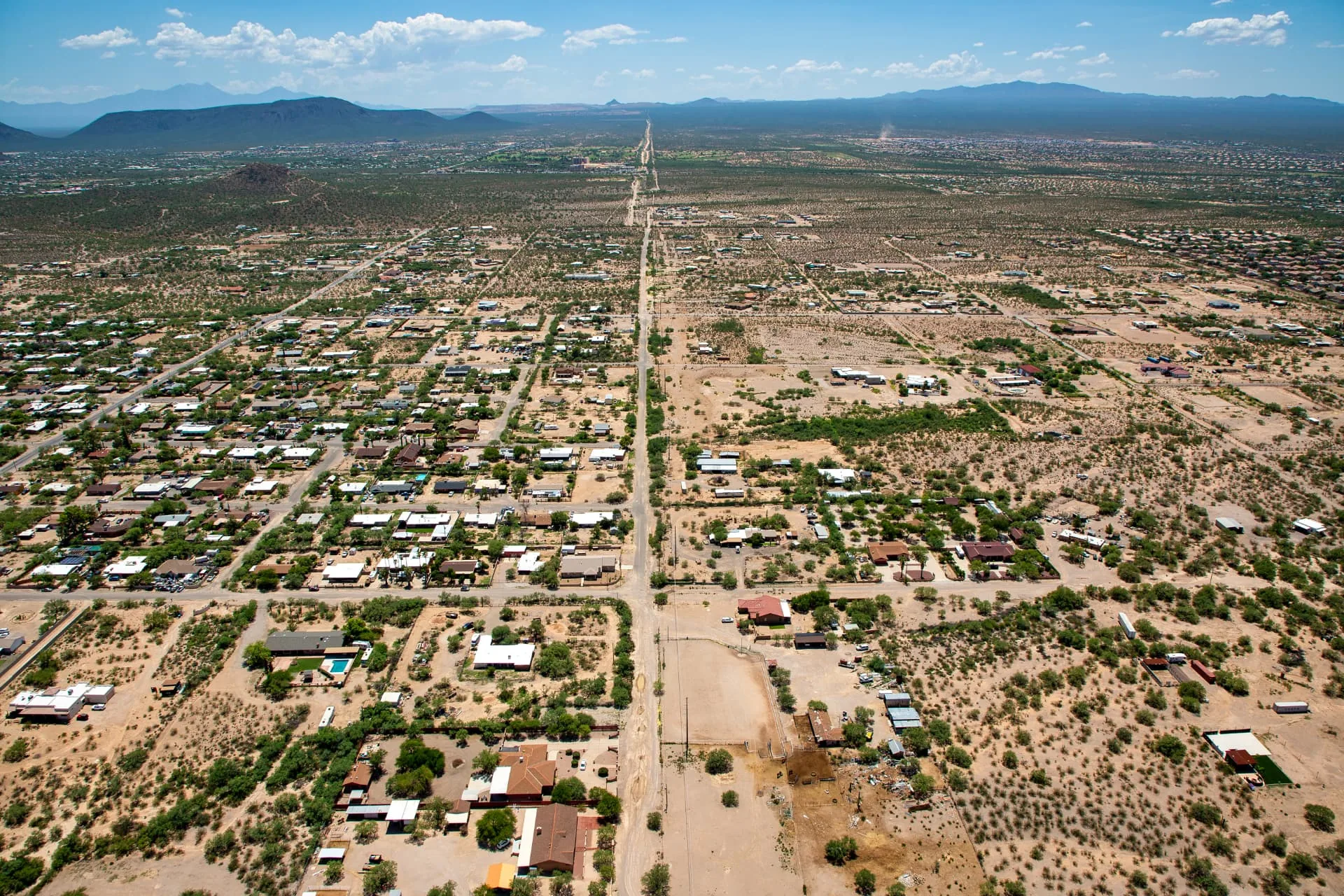 Aerial view of a desert residential grid outside Phoenix, Arizona with mountains on the horizon